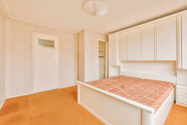 Köşeye yumuşak bir yatak odası, ahşap gardırop ve lamba aydınlatmalı raflar dizayn edilmiş.