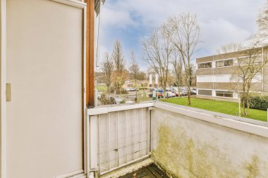 Kırsal kesimi tarif eden kaldırım ve bitki örtüsü olan binaların ön manzarası