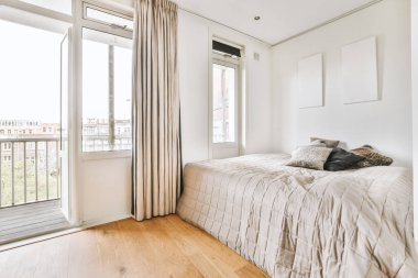 Mutfağın yanındaki aydınlık oturma odasında yatağın yanındaki zarif avizenin altında yumuşak yastıklı büyük bir kanepe.