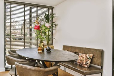 Günümüz mutfağının içinde modern dairenin yemek alanı yakınında şık siyah dolaplar ve aletler var.