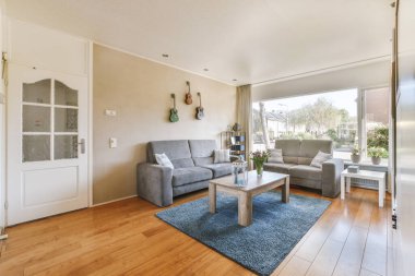 TV 'nin yanındaki koltuklar ve masa, çağdaş apartmandaki geniş odalı yemek alanına karşıdır.