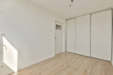 Evdeki boş ışık odasında, beyaz duvardaki plastik pencere ve radyatör.