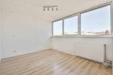 Ahşap parke zeminli geniş balkon pencereli boş beyaz odanın içi