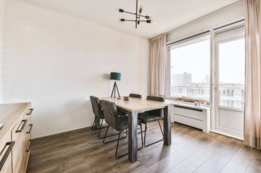 Çağdaş dairenin pencerelerine karşı rahat kanepesi ve televizyonu olan oturma odası.