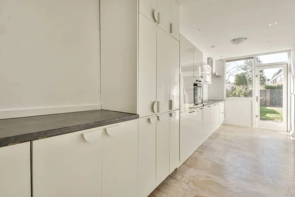 Spacious bright kitchen with white walls and tiled floor