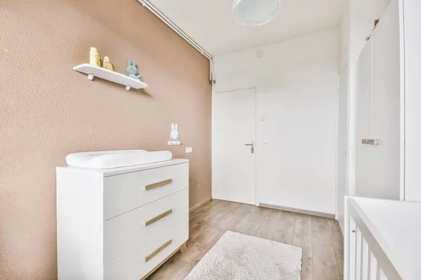 Minimalist interior design of small bedroom with soft bed placed in corner and wooden wardrobe and shelves with lamp illumination