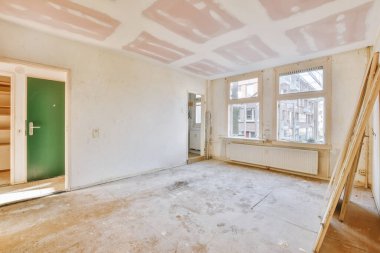 Evdeki boş ışık odasında, beyaz duvardaki plastik pencere ve radyatör.