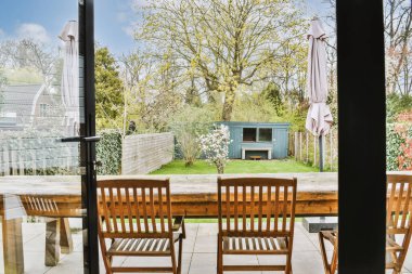 Oturma alanı ve ahşap çitin yanında küçük bir bahçesi olan düzgün asfaltlı bir teras.