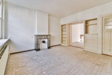 Tabureli modern tezgahlar, beyaz duvarlı, geniş odalı şöminenin yanındaki ahşap zemine yerleştirilmiş.