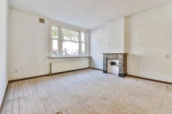 白壁の広々とした部屋で暖炉の近くの木製の床に置かれたスツール付きのモダンなカウンター — ストック写真