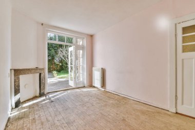 Tabureli modern tezgahlar, beyaz duvarlı, geniş odalı şöminenin yanındaki ahşap zemine yerleştirilmiş.