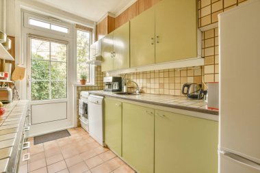 Ahşap duvarları ve döşemeleri olan geniş, parlak bir mutfak.