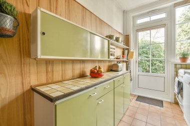 Ahşap duvarları ve döşemeleri olan geniş, parlak bir mutfak.