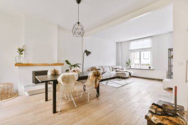 TV 'nin yanındaki koltuklar ve masa, çağdaş apartmandaki geniş odalı yemek alanına karşıdır.