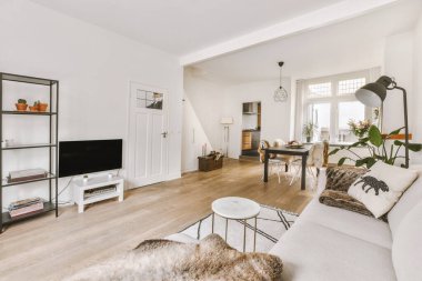 TV 'nin yanındaki koltuklar ve masa, çağdaş apartmandaki geniş odalı yemek alanına karşıdır.