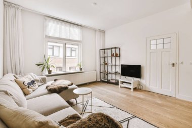 TV 'nin yanındaki koltuklar ve masa, çağdaş apartmandaki geniş odalı yemek alanına karşıdır.