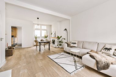 TV 'nin yanındaki koltuklar ve masa, çağdaş apartmandaki geniş odalı yemek alanına karşıdır.