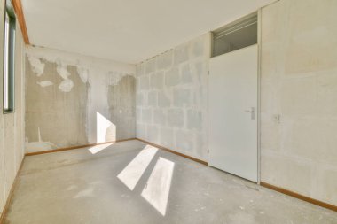 Evdeki boş ışık odasında, beyaz duvardaki plastik pencere ve radyatör.