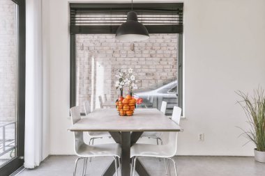 Modern dairenin geniş oturma odasındaki şık mobilyaların üzerinde asılı süslü lamba.