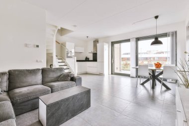 Modern dairenin geniş oturma odasındaki şık mobilyaların üzerinde asılı süslü lamba.