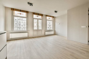 Evdeki boş ışık odasında, beyaz duvardaki plastik pencere ve radyatör.