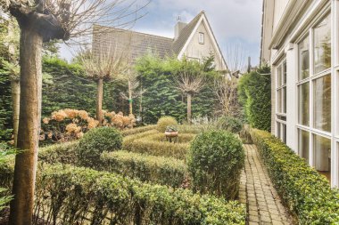 Oturma alanı ve ahşap çitlerin yanındaki küçük bahçesi olan düzgün asfaltlı bir avlu.