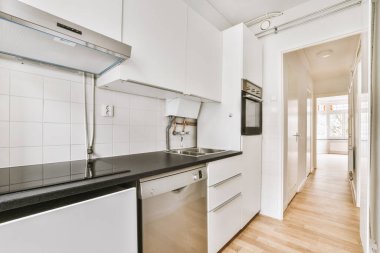 Minimalist tarzı beyaz mobilyalı, lavabolu ve sobalı bir ev mutfağı.