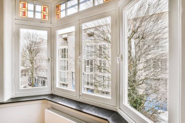 Evdeki boş ışık odasında, beyaz duvardaki plastik pencere ve radyatör.