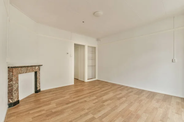 Modern counters with stools placed on wooden floor near fireplace in spacious room with white walls