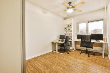 Çağdaş düz ofis bilgisayar monitörleri ile masanın yanına konforlu sandalye