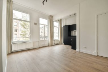 Evdeki boş ışık odasında, beyaz duvardaki plastik pencere ve radyatör.