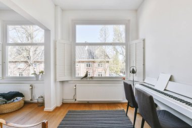 Modern apartmandaki geniş minimalist tarzda oturma odasında halı ve masaya yakın rahat bir kanepe.