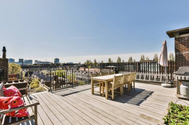 Metal parmaklıklı balkon, tahta sandalye ve kapı.