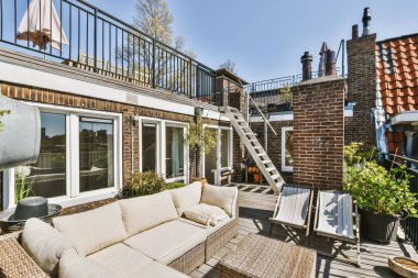 Metal parmaklıklı balkon, tahta sandalye ve kapı.