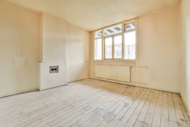 Evdeki boş ışık odasında, beyaz duvardaki plastik pencere ve radyatör.