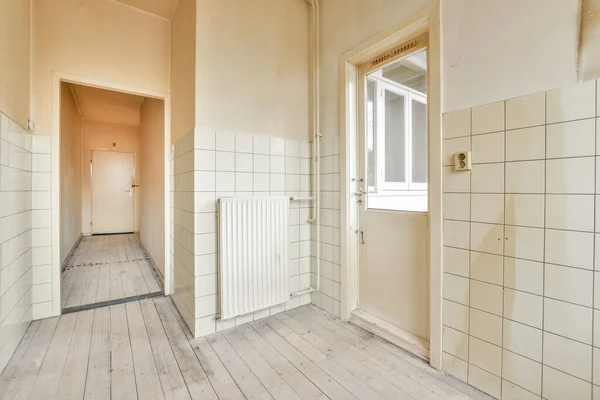 Interior of empty white kitchen with corridor and wooden parquet floor