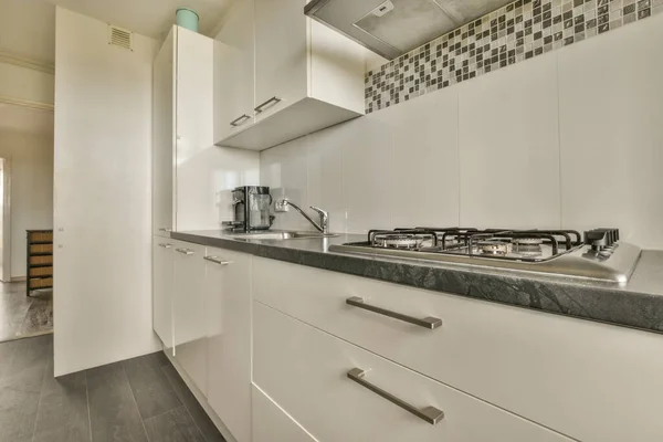 Minimalist Tarzı Beyaz Mobilyalı Lavabolu Sobalı Bir Mutfağı — Stok fotoğraf