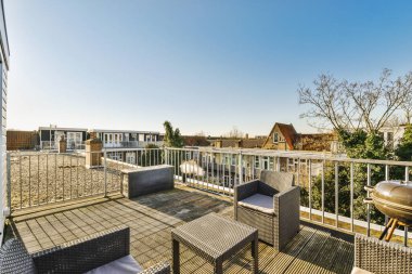 Apartmanın terasından panoramik manzara. Sandalyeli bir kanepesi ve barbeküsü var.