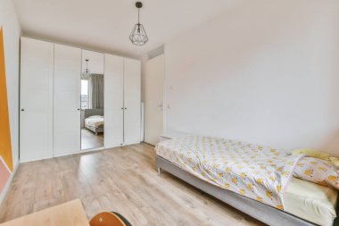 Modern çocuk odasının içinde yatak odası, çalışma masası ve evde gardırop var.