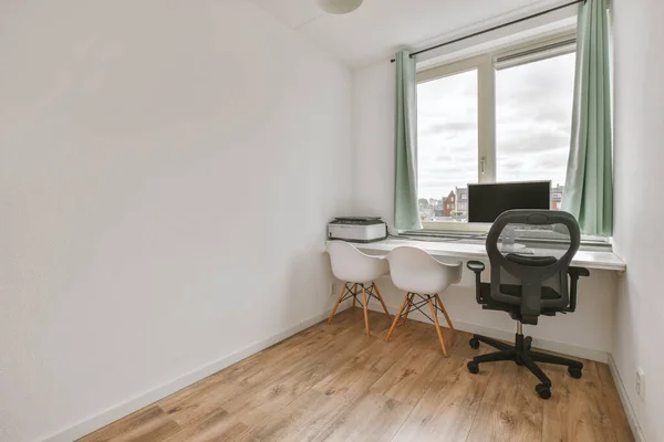 Minimalist interior of study room with parquet floor and white walls furnished with settee and table