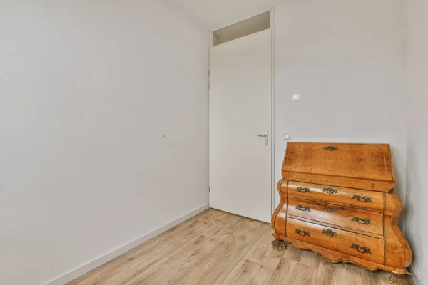 Minimalist interior of study room with parquet floor and white walls furnished with settee and table