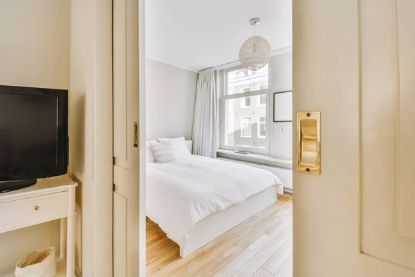 現代のアパートの窓の近くの隅にベッドと木製のワードローブとベッドルームの家のインテリアデザイン — ストック写真