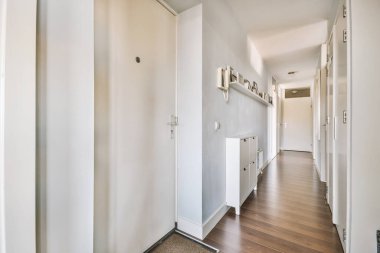 Dar koridorun içinde, gün ışığında duvarda telefon ve radyatör asılı.