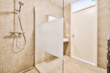 Çağdaş banyo küveti ve cam duş kabini açık bej fayanslı ve beyaz tavanlı