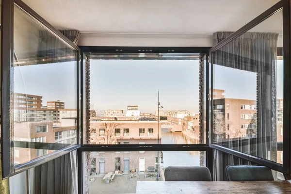 Panoramic view of the city and the flood canal from the window of the living room of an apartment building