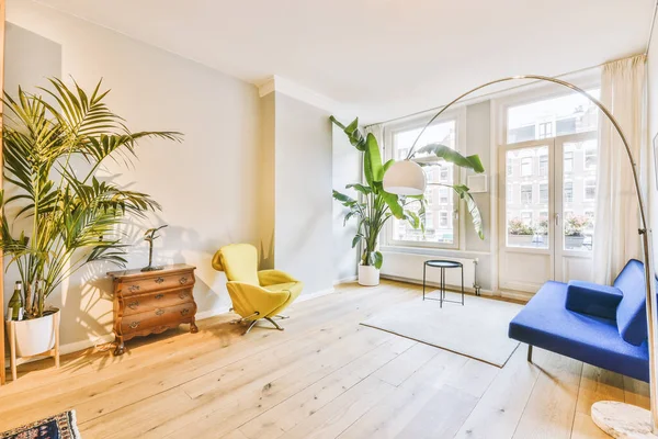 舒适的沙发坐落在现代公寓宽敞简约风格客厅的地毯和靠窗的桌旁 — 图库照片