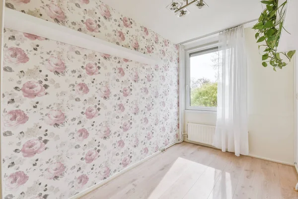 Spacious bright white room with winSpacious bright room with window and wall with floral wallpaper, white radiator and curtainsdow with