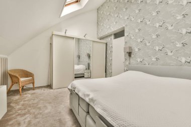 Geniş, parlak bir tavan arası, minimalist bir çalışma masası ve geniş bir panoramik penceresi var.