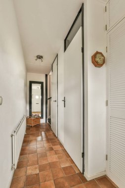 Beyaz radyatörlü ferah, parlak bir koridor ve pencereli döşeme.