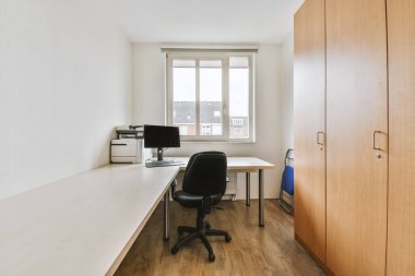 Masanın yanına konforlu sandalye, günümüzün düz ofisindeki boş beyaz tahtaya karşı bilgisayar monitörleriyle yerleştirilmiş.